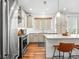 Well-lit kitchen showcasing stainless steel appliances, light cabinets, and a granite countertop island at 5738 Urban Ctr, Arvada, CO 80002