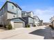 An eye-level view of newly built townhomes, each featuring a private garage in a row at 5738 Urban Ctr, Arvada, CO 80002