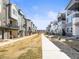 View of modern townhomes lining a grassy common area in a well-maintained community at 5738 Urban Ctr, Arvada, CO 80002