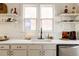 Bright kitchen featuring a white sink, black faucet, marble countertops, and open shelving at 321 Fox St, Denver, CO 80223