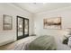 Serene bedroom with natural light from balcony access, light wood floors, and neutral decor at 2111 E Alameda Ave, Denver, CO 80209