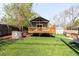 Spacious backyard featuring deck, lawn, storage shed, and mature trees at 2520 S Race St, Denver, CO 80210