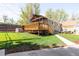Expansive backyard featuring a deck, lawn, and mature trees at 2520 S Race St, Denver, CO 80210