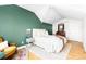 Well-lit bedroom featuring hardwood floors, a green accent wall, and neutral decor at 2520 S Race St, Denver, CO 80210