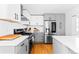 Modern kitchen featuring white cabinets, hardwood floors, quartz countertops, and stainless steel appliances at 2520 S Race St, Denver, CO 80210