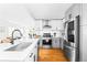 Bright kitchen featuring a large stainless steel refrigerator, white cabinets, hardwood floors, and an island sink at 2520 S Race St, Denver, CO 80210