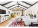 Bright living room with vaulted ceilings, wood beams, hardwood floors, and a cozy wood-burning stove at 2520 S Race St, Denver, CO 80210