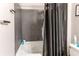 Bathroom features a white tub and shower with gray tile surround and black shower curtain at 1575 Olympia Cir # 307, Castle Rock, CO 80104