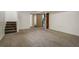 Spacious carpeted basement with stairs and open doorway to another room at 19000 E Mansfield Dr, Aurora, CO 80013