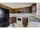 Cozy kitchen with brown cabinets, stainless steel microwave, and white oven appliance at 19000 E Mansfield Dr, Aurora, CO 80013