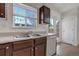 Bright kitchen features a double sink, white dishwasher, and a window with natural light at 19000 E Mansfield Dr, Aurora, CO 80013