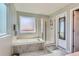 Bathroom featuring a soaking tub, a glass enclosed shower, and a neutral color palette at 9408 High Cliffe St, Highlands Ranch, CO 80129