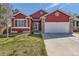 Charming red home with a well-maintained lawn, two-car garage and brick-accented entryway at 9408 High Cliffe St, Highlands Ranch, CO 80129