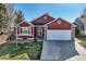 Charming two-story home with manicured front yard, white garage door, and a red exterior at 9408 High Cliffe St, Highlands Ranch, CO 80129