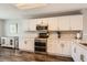 Well-lit kitchen features white cabinets, stainless steel appliances, and sleek, dark-wood flooring at 9408 High Cliffe St, Highlands Ranch, CO 80129