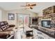 Spacious living area with stone fireplace, ceiling fan, access to outdoor patio and comfortable seating at 9408 High Cliffe St, Highlands Ranch, CO 80129