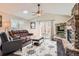 Spacious living room boasts wood floors, stone fireplace, ceiling fan, and French doors to the backyard at 9408 High Cliffe St, Highlands Ranch, CO 80129