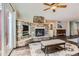 Cozy living room featuring a stone fireplace, wooden floors, a ceiling fan and plenty of natural light at 9408 High Cliffe St, Highlands Ranch, CO 80129