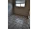 A compact bedroom with a window, tile flooring, and neutral wall paneling at 15003 Olmsted Dr, Denver, CO 80239