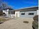 Single-story home featuring a convenient access ramp and attached gray garage at 15003 Olmsted Dr, Denver, CO 80239