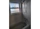 A bathtub and shower with white tiles are enhanced by natural light from a window at 15003 Olmsted Dr, Denver, CO 80239