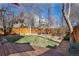 Spacious backyard with a wooden deck, green grass, mature trees, and privacy fence at 1723 E 16Th Ave, Denver, CO 80218