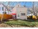 View of the home's back exterior, including a deck, patio set, and grassy lawn at 1723 E 16Th Ave, Denver, CO 80218