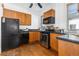 Kitchen featuring stainless steel appliances, wood cabinets, and black countertops at 1723 E 16Th Ave, Denver, CO 80218