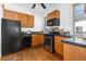 Kitchen featuring stainless steel appliances, wood cabinets, and black countertops at 1723 E 16Th Ave, Denver, CO 80218