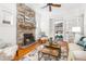 Cozy living room featuring a stone fireplace, hardwood floors, and access to the sunroom at 1723 E 16Th Ave, Denver, CO 80218