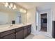 Elegant bathroom features a double sink vanity with dark wood cabinets and access to a walk-in closet at 6492 N Ceylon St, Denver, CO 80249