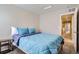 Bright bedroom with blue bedding, neutral walls, and a view to the hallway at 6492 N Ceylon St, Denver, CO 80249