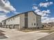 Townhome complex features manicured lawns and attached garages on a sunny day at 6492 N Ceylon St, Denver, CO 80249