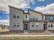 Modern townhouse exterior features a gray facade, red door, and desert-style landscaping at 6492 N Ceylon St, Denver, CO 80249