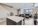 Open concept living room adjacent to kitchen area with hardwood-style floors, a large couch, and staircase at 6492 N Ceylon St, Denver, CO 80249