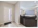 A modern living room and foyer featuring a plush couch, large screen TV, and white front door at 6492 N Ceylon St, Denver, CO 80249