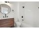 Modern bathroom features a vanity with black fixtures, a round mirror and a bathtub with white tile surround at 6539 Pinewood Dr # 57, Parker, CO 80134