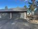 Double garage with grey doors and exterior landscaping at 6539 Pinewood Dr # 57, Parker, CO 80134