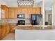 Kitchen features an island, wood cabinets, and stylish lighting at 15455 Canyon Rim Dr # 307, Englewood, CO 80112