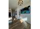 Inviting living room featuring wood floors, a modern light fixture, and a large wall-mounted television at 15455 Canyon Rim Dr # 307, Englewood, CO 80112