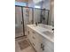 Modern bathroom featuring double sinks, white cabinets, a glass-enclosed shower, and stylish black hardware at 13432 Broad Wing Dr, Parker, CO 80134
