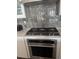 Focus on the stainless steel gas range and backsplash in this modern, well-appointed kitchen at 13432 Broad Wing Dr, Parker, CO 80134
