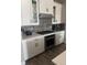 Gourmet kitchen boasts stainless steel appliances, gray backsplash, sleek white cabinets, and ample counter space at 13432 Broad Wing Dr, Parker, CO 80134