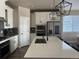Modern kitchen featuring an island with a quartz countertop, stainless steel appliances, and stylish pendant lighting at 13432 Broad Wing Dr, Parker, CO 80134