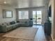 Bright living room with comfortable seating, large window and sliding glass doors to the deck at 13432 Broad Wing Dr, Parker, CO 80134
