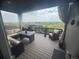 Covered patio with seating and views of open space with distant barn, table, chairs, lounge, and curtains at 13432 Broad Wing Dr, Parker, CO 80134