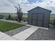 Backyard with shed, landscaped bed of rock, small shrubs, and lawn with views of open space beyond the property line at 13432 Broad Wing Dr, Parker, CO 80134
