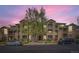 Inviting condo building with well-maintained landscaping and multiple balconies under a beautiful pink sunset at 2985 Blue Sky Cir # 7-107, Erie, CO 80516