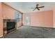 Open living room with plush carpeting, decorative ceiling fan, and a fireplace with a glass door to the patio at 2985 Blue Sky Cir # 7-107, Erie, CO 80516
