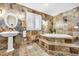 Bathroom featuring a soaking tub, a window, and tiling throughout at 19070 White Fawn Dr, Monument, CO 80132